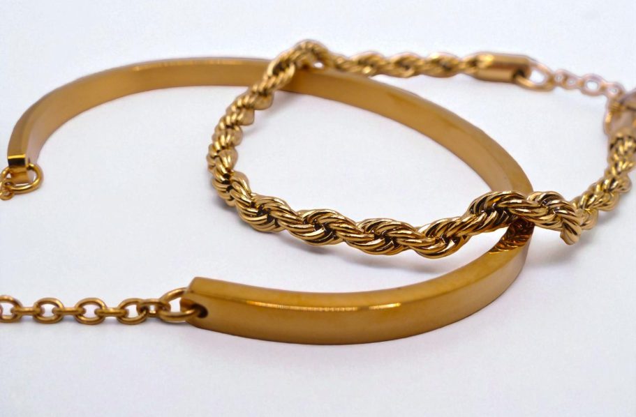 Bracelets en or, l'un lisse et l'autre torsadé, posés sur un fond blanc.